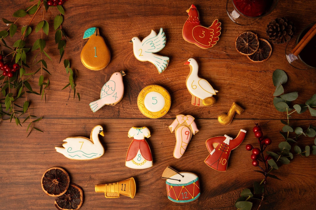 Hand-iced Biscuiteers 12 Days of Christmas biscuits in a festive tin, perfect for personalized holiday gifts.