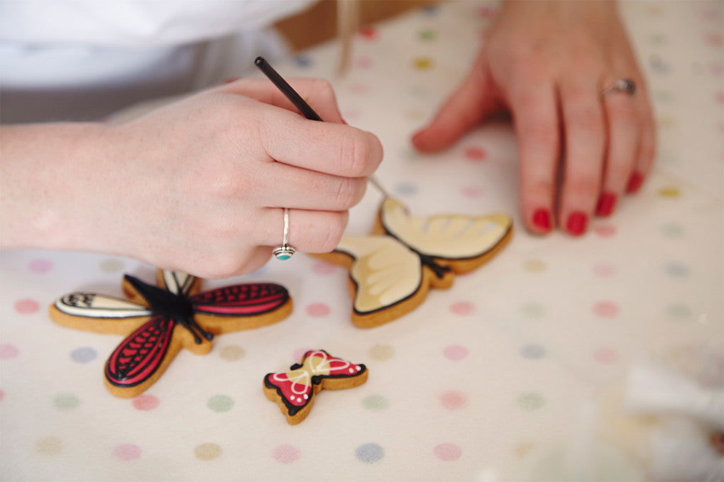 Hand-iced butterfly biscuits from School of Icing, perfect personalised birthday gift in a decorative biscuit tin.