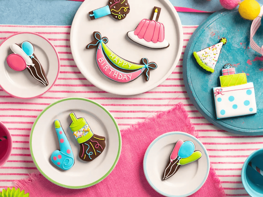 Hand-iced birthday biscuits by Biscuiteers, perfect personalised gifts for him, featuring cakes, balloons, and party hats.