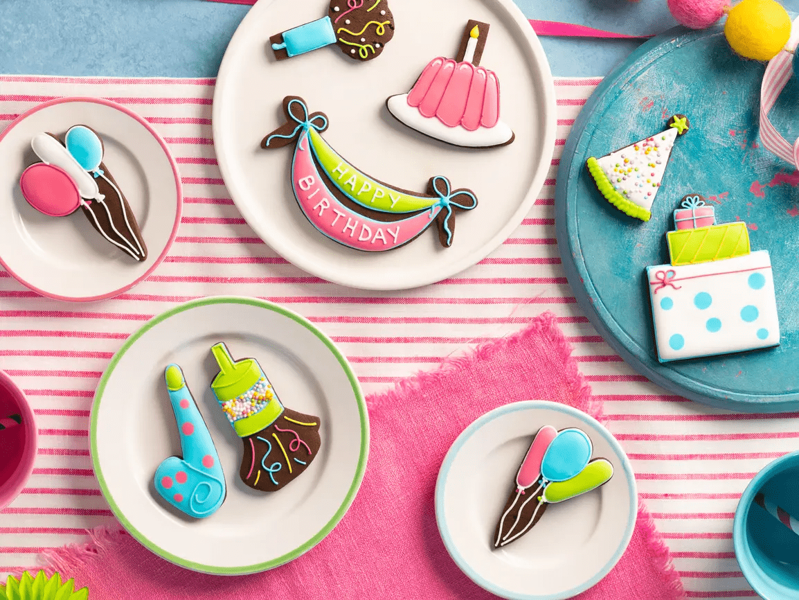 Hand-iced birthday biscuits by Biscuiteers, perfect personalised gifts for him, featuring cakes, balloons, and party hats.