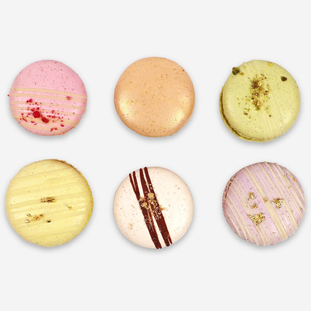 Hand-iced Mother's Day macarons, perfect personalized gift for mom, featuring elegant designs in a biscuit tin gift set.